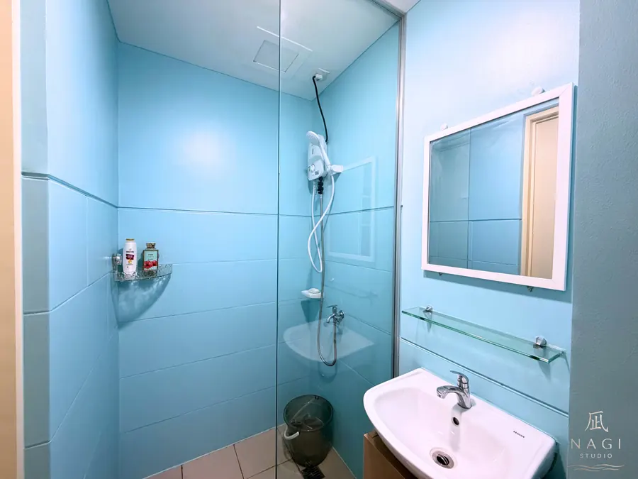 NaGi Studio bathroom shower area with toiletries